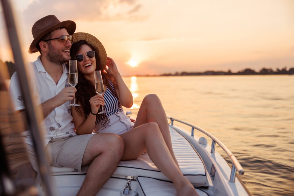 Couple drinking champagne while sailing towards the sunset on a boat in Cyprus, embracing the Cyprus lifestyle.