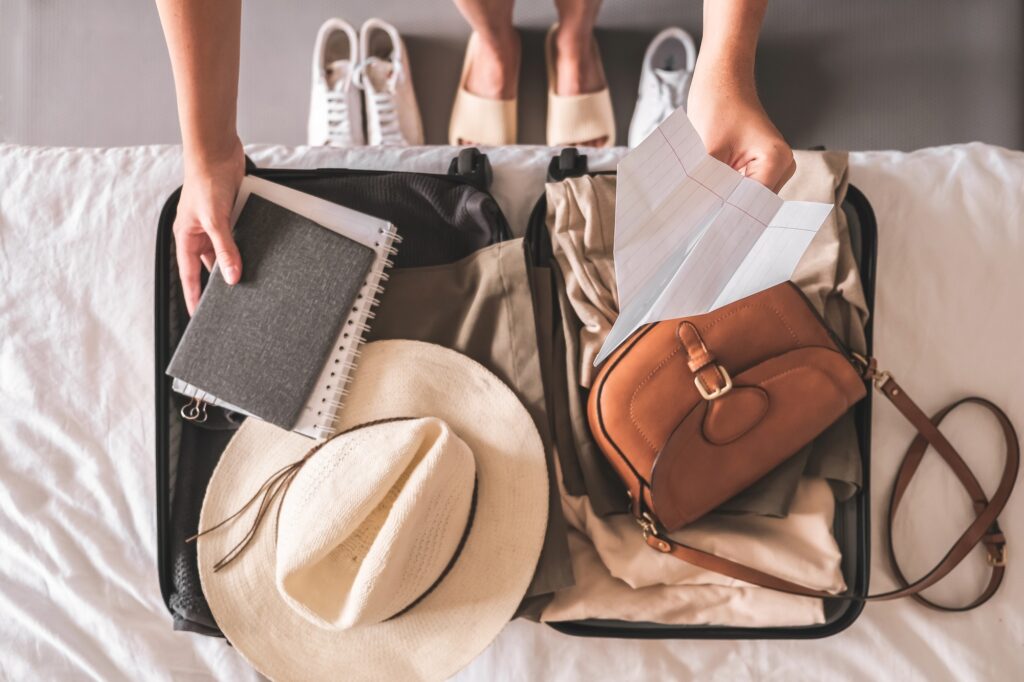 Woman packing a suitcase, getting ready to move abroad to a tax-friendly country for expats.